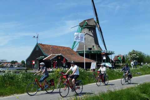 Cyclistes pédalant devant un moulin dans le nord de la Hollande