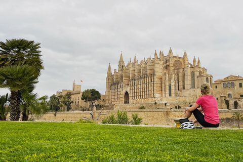 Cyclotouriste en pause devant la cathédrale de Palma