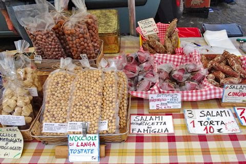 Etal de marché piémontais avec les produits traditionnels locaux : noisettes, charcuterie