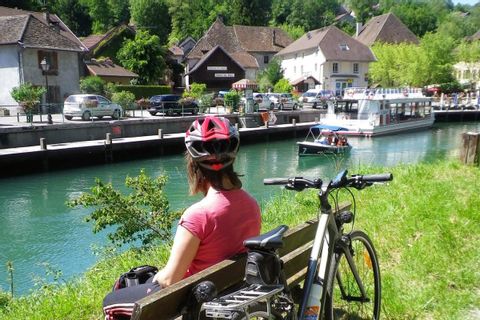 Cycliste faisant une pause sur un banc au bord du canal à Annecy