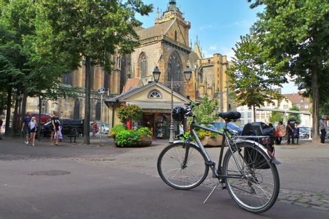 Vélo de location Espace Randonnée garé devant la Collégiale de Colmar