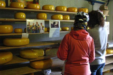 Deux cyclotouristes visitent la boutique d'une fromagerie vendant du Gouda aux Pays-Bas