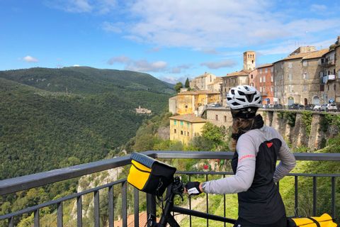 Cycliste observe un panorama impressionnant pendant ses vacances à vélo entre Florence et Rome