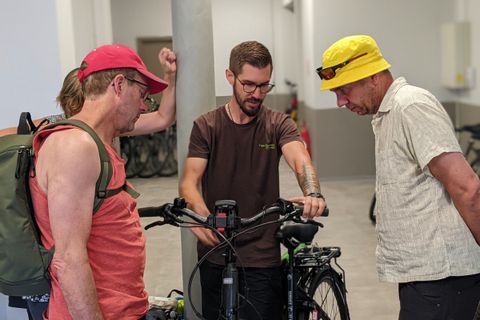 Notre collaborateur Julien remet les vélos de location à un groupe de clients s'apprêtant à débuter leur circuit en Alsace