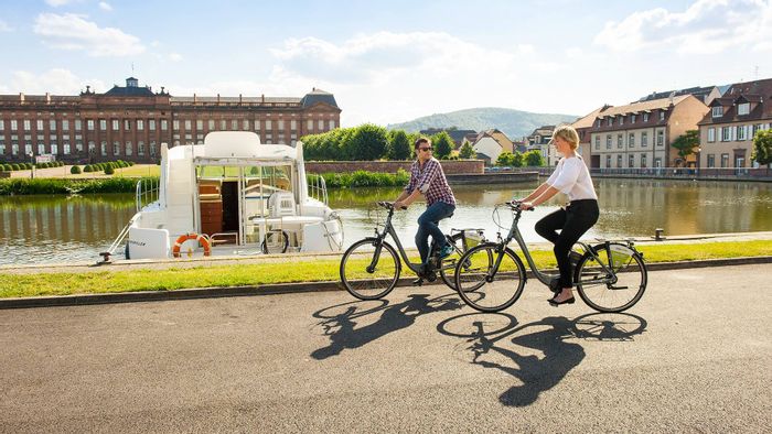 Deux cyclistes se promènent au bord du port fluvial de Saverne en Alsace