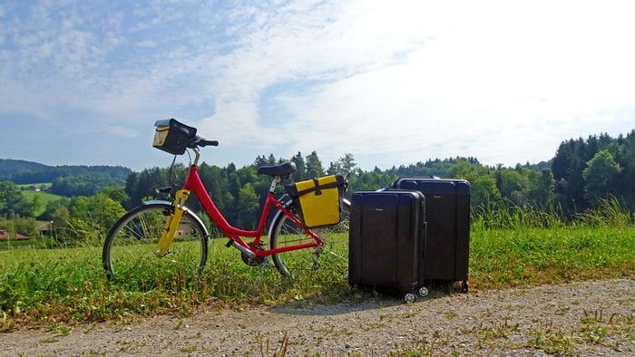 Deux valises posées à côté d'un vélo de randonnée 