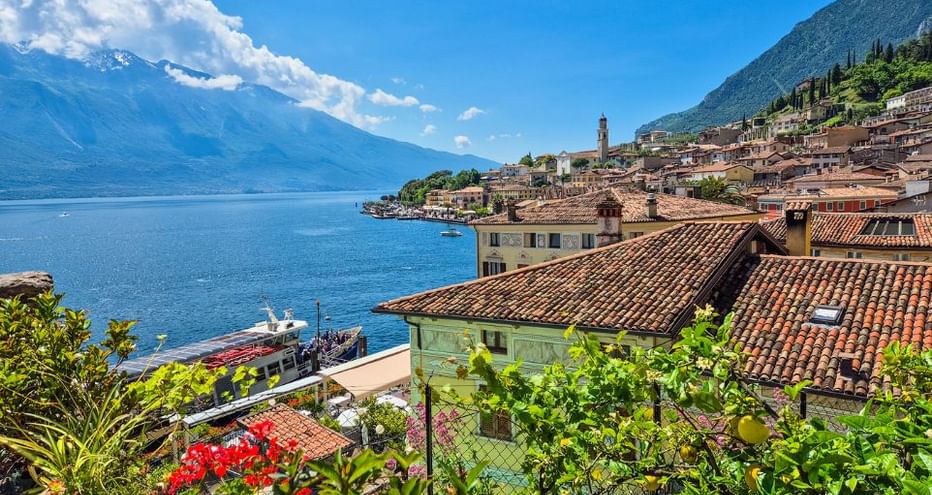 Vue pittoresque de Limone sul Garda avec maisons italiennes traditionnelles, toits de tuiles rouges et jardins luxuriants sur le lac de Garde.