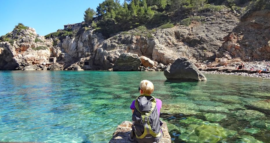 Randonneuse prend une pause dans la magnifique baie de Deia, à Majorque